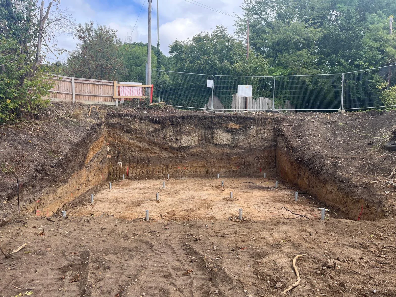Basement excavation with ground-screw foundations exposed